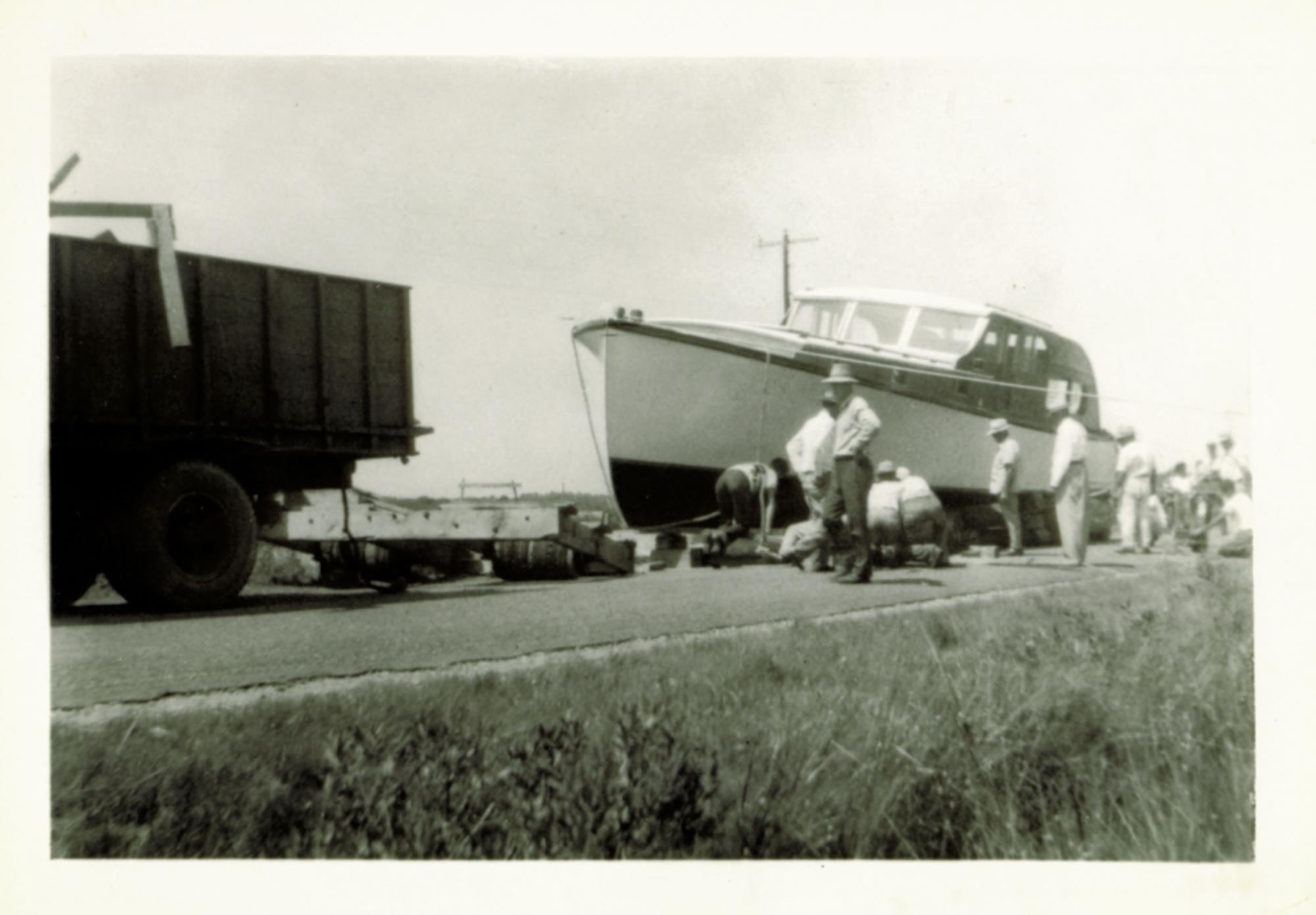 Bronza and his crew move a power cruiser to the water for launch. Undated.