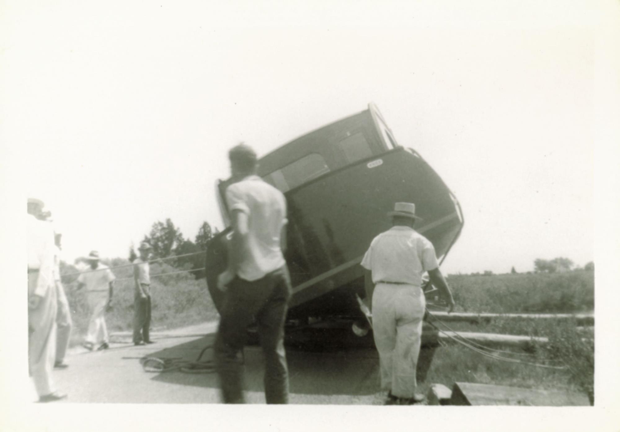 Bronza's neighbors gather to watch and help. Undated.