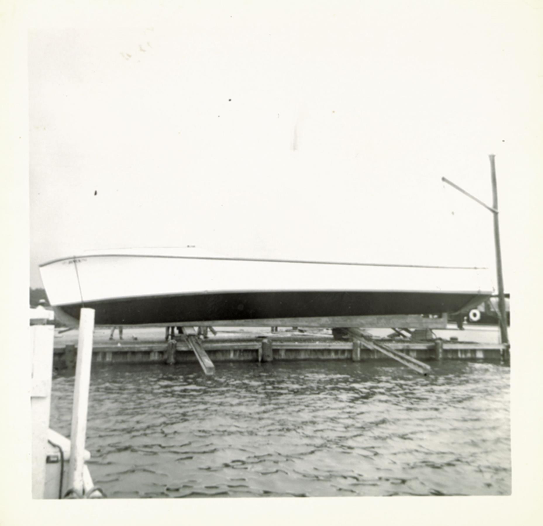 Sliding a workboat over the bulkhead into the water. 26 October 1955.