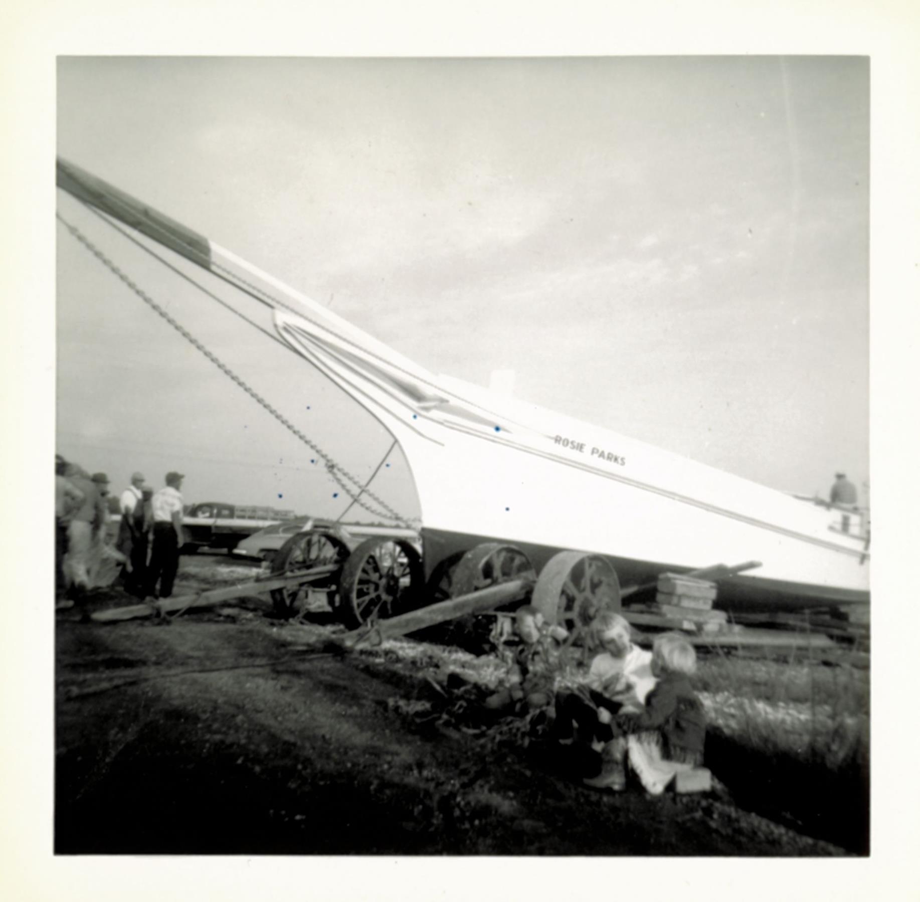 A clear view of the wheeled undercarriages used to move Rosie Parks and other skipjacks to the water. Three of Bronza's grandchildren - "Pres", Brenda, and Candie - in the foreground. October 1955.