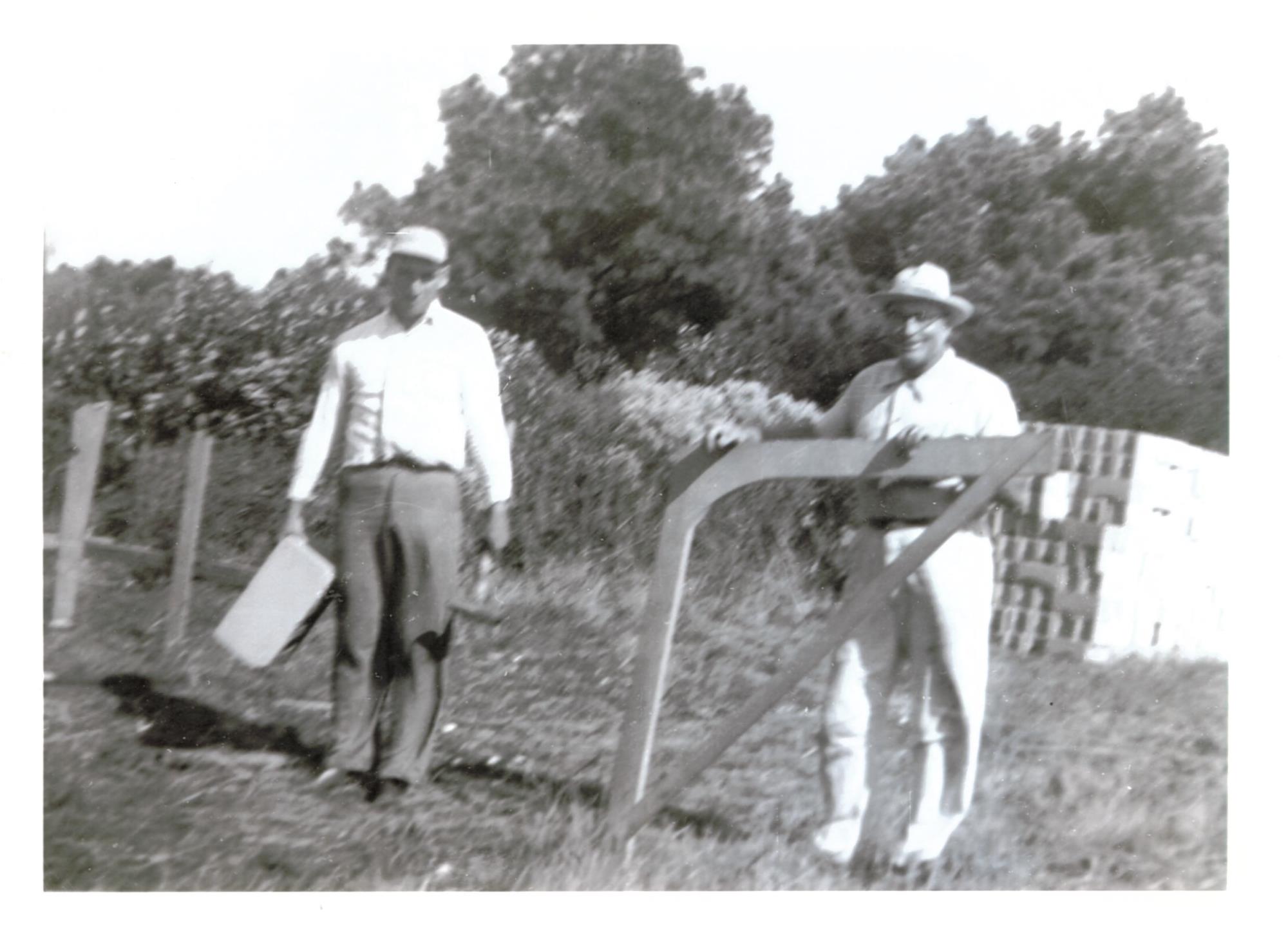 Bronza Parks and Clarence Jones holding line square for laying out cornerstones of the new firehouse on land that Bronza donated .